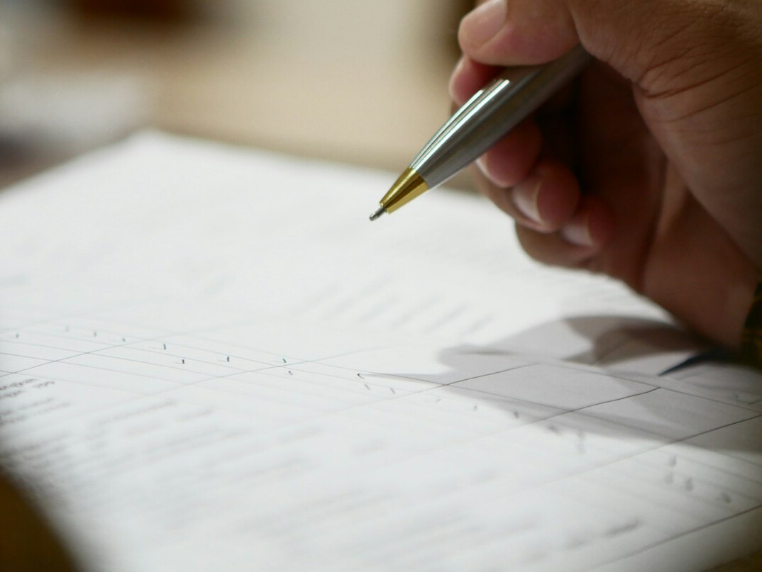 person writing budget on paper